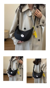 Detail of black crescent crossbody bag with quilted texture and cartoon duck charm