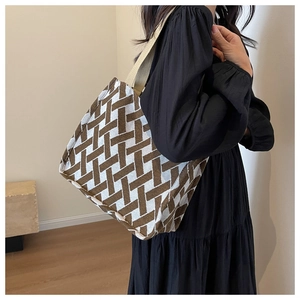 Close-up of geometric knit tote bag featuring a textured brown and white weave pattern