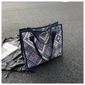 Vue détaillée d'un grand sac cabas en toile ethnique avec motifs géométriques sur asphalte