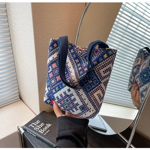 Close-up of ethnic knit bucket bag featuring colorful geometric patterns and metal snap button