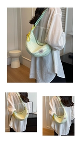 Detail of mint green quilted hobo bag with yellow lanyard and 'good luck' patch