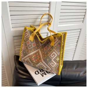 Détail d'un sac cabas ethnique tissé aux motifs géométriques et anses en toile jaune