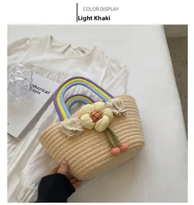 Detail of light khaki straw handbag with rainbow cotton handles and a yellow fabric flower