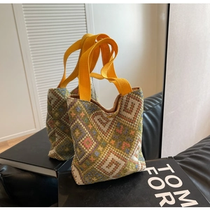 Macro view of ethnic woven tote bag with colorful geometric patterns and yellow handle