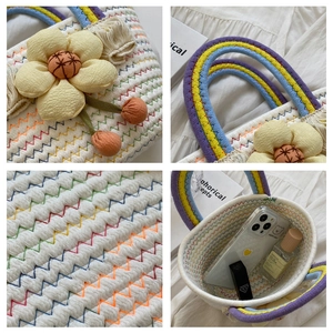 Detail of handwoven bag showing colorful wave stitching, 3D floral accent and tassel