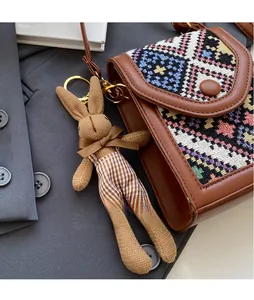 Detailed shot of brown crossbody bag with ethnic patterns and a cute rabbit charm accessory