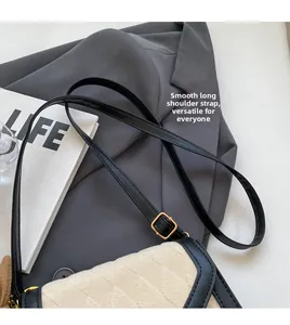 Gros plan sur la bandoulière réglable et la texture matelassée du petit sac carré