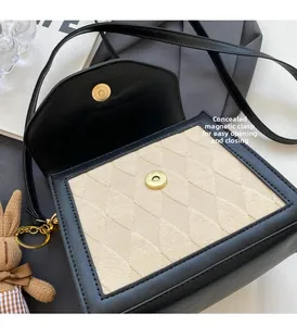 Détail du sac bandoulière en cuir noir avec fermoir magnétique et petit pendentif lapin