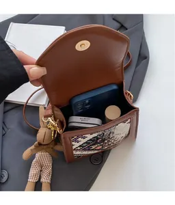 Interior view of brown woven crossbody bag showing capacity for phone and lipstick