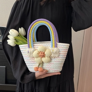 Handwoven basket bag with rainbow rope handle and decorative yellow fabric flower