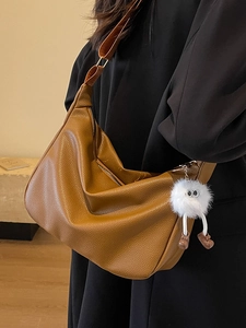 Brown litchi grain soft leather hobo bag with wide strap and plush monster charm