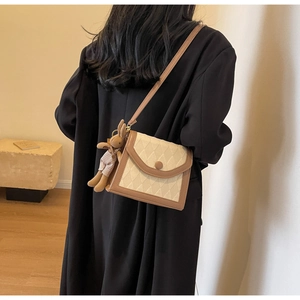 Détail du sac en tissu matelassé crème et cuir marron avec pendentif lapin mignon