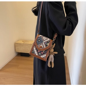 Ethnic style crossbody bag with geometric embroidery and cute bunny plush charm on a model