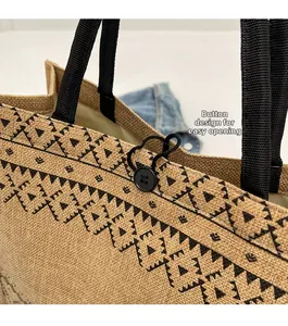 Détail d'un sac cabas en jute avec motifs géométriques noirs et fermeture à bouton