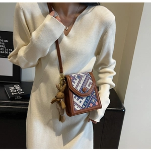 Ethnic crossbody bag with geometric fabric pattern and plush bunny pendant on side