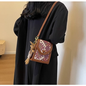 Detailed shot of ethnic patterned crossbody bag with a cute plush rabbit charm