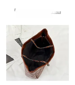 Detailed view of spacious interior of brown quilted tote bag with chain strap