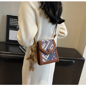 Detailed close-up of ethnic crossbody phone bag with geometric pattern and bunny charm