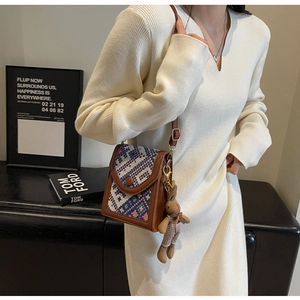Close-up of ethnic style jacquard crossbody bag with a cute plush rabbit pendant charm
