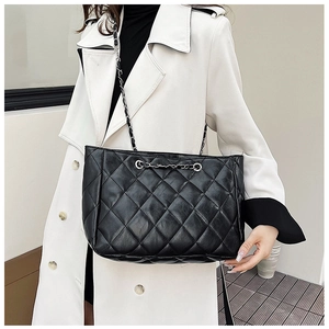 Detailed view of black quilted leather tote bag with elegant metal chain straps