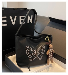 Detail of black pebbled leather tote with pink butterfly embroidery and rabbit charm