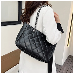 Chic black quilted tote bag with silver chain strap shown on a female model for daily use