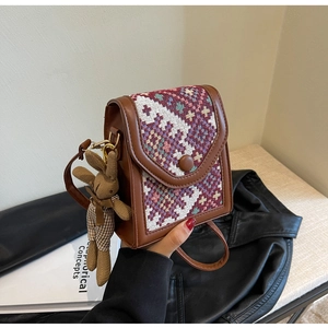Detail of retro ethnic style crossbody bag with tweed texture and cute rabbit pendant