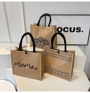 Detailed shot of three linen jute tote bags with black handles and ethnic print designs
