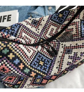 Detail of a geometric ethnic canvas bag showing smooth double zipper closure