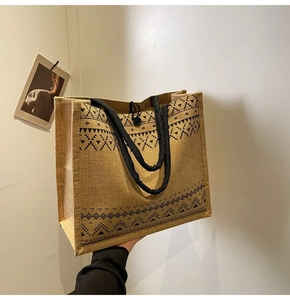 Detailed view of yellow linen tote bag with black geometric ethnic patterns and rope handles