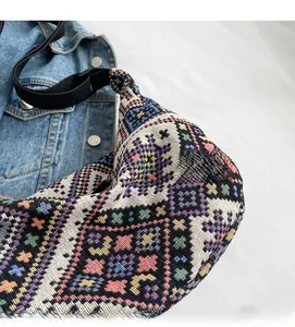 Close-up of ethnic geometric woven pattern and durable black shoulder strap on hobo bag