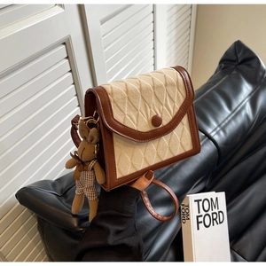 Détail du sac bandoulière matelassé beige vintage avec bordure brune et peluche lapin