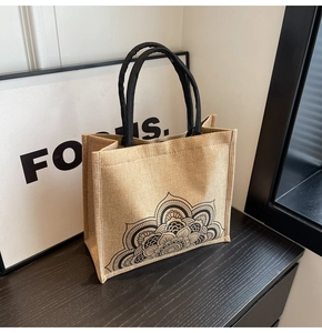 Detailed view of natural jute tote bag with black floral mandala and thick rope handles