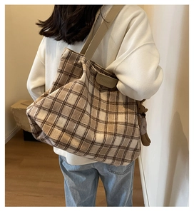 Close-up of wool plaid tote bag with FASHION leather tag and cute bunny doll pendant