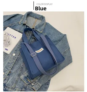 Detail of blue canvas tote bag with adjustable strap and FASHION label on denim jacket
