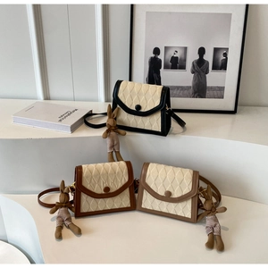 Détail de sacs à bandoulière matelassés avec boutons vintage et breloques lapin mignon