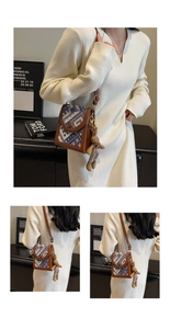 Close-up of woven ethnic crossbody bag with brown leather trim and cute rabbit charm