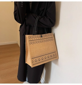 Linen tote bag with black geometric patterns shown being carried by a model