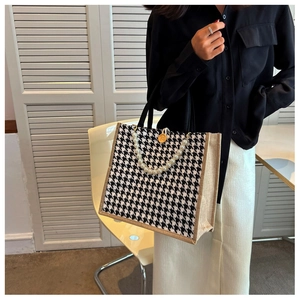 Close-up of houndstooth tote bag with pearl handle and vintage wooden button detail