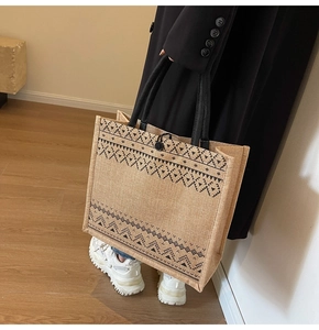 Detailed view of bohemian geometric pattern on a large linen tote bag with black handles