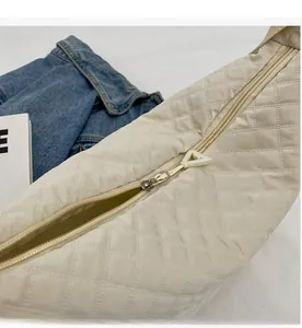 Détail de la fermeture éclair fluide et du motif matelassé du sac à bandoulière crème