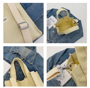 Detail view of cream canvas bag features adjustable straps and silver metal hardware