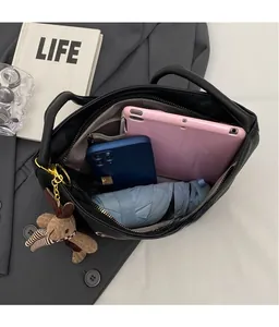 Top view of spacious black leather tote bag interior showing iPad, phone and umbrella