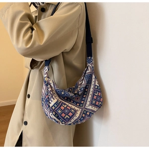 Detail view of ethnic style woven crescent bag featuring colorful geometric patterns
