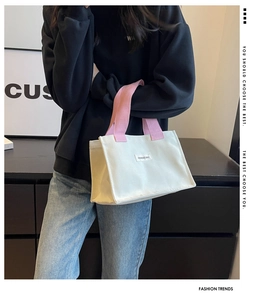 Détail du sac cabas en toile avec corps crème et poignées roses et étiquette mode
