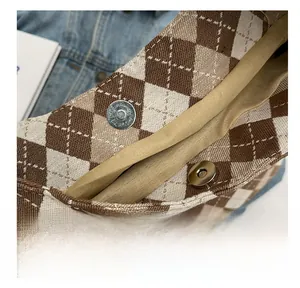 Macro shot of the secure magnetic metal clasp on the checkered canvas tote bag