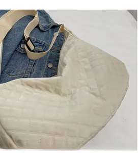 Détail du sac à bandoulière matelassé crème avec sangle tissée réglable et texture