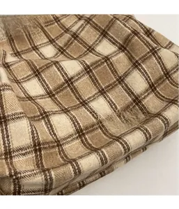 Detailed macro view of checkered wool fabric with an embossed FASHION leather patch