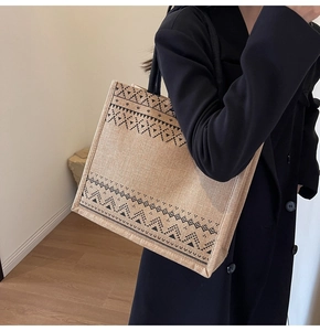 Detailed close-up of large jute tote bag with black geometric patterns and woven handles
