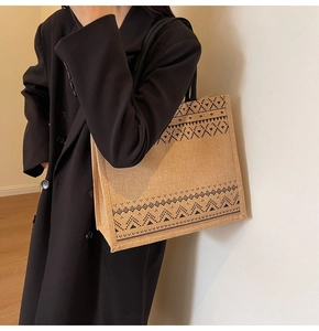 Detailed side view of a large linen tote bag with geometric patterns and black rope straps